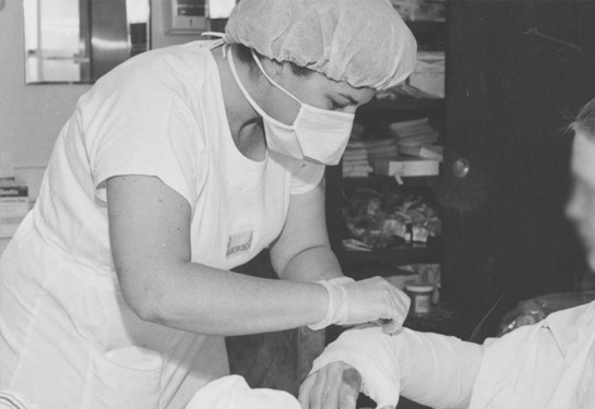 Nurse tends to the bandaged arm of burn patient