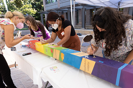 People around a table creating postcards for a peace pole