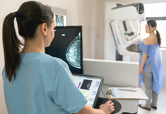Female health professional checking mammogram x-ray on screen