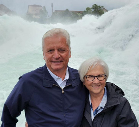 Cheryl Joordens and her husband Tony posing in front of foaming waves at Bodensee (Lake Constance) in Germany.