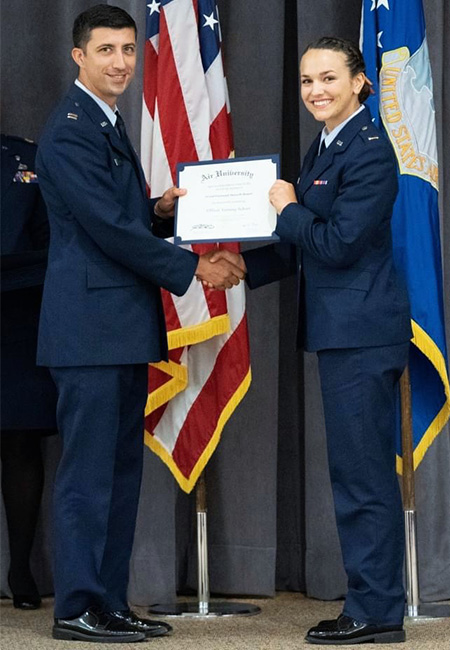 Air Force 2nd Lt. Shania Bennett receives a diploma from a flight instructor for having successfully completed Officer Training School Class 22-07