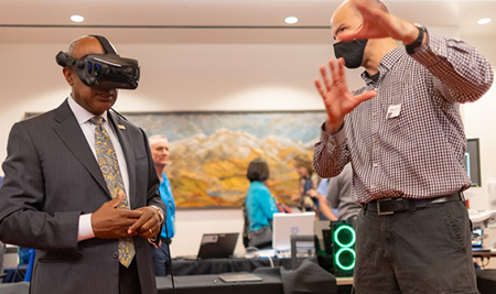 Man wearing blue suit with virtual reality goggles over his eyes