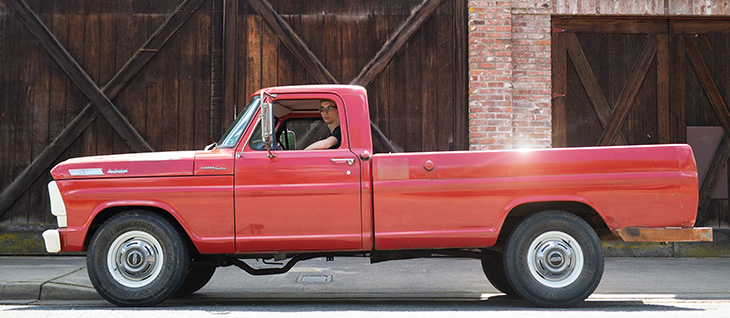Young man in a red vintage truck