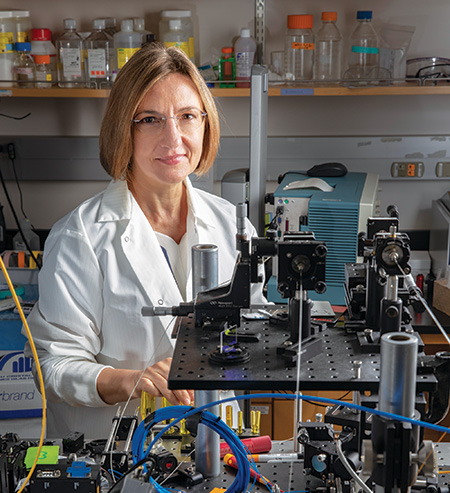 Dr. Laura Marcu in a white coat in her lab