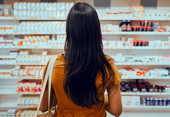 Woman looks at pharmacy shelf