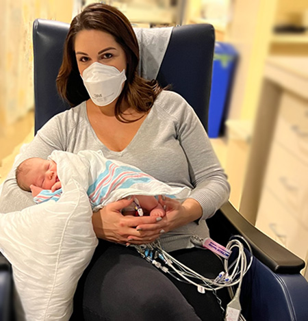 Ashley with Adelyn sitting in a chair