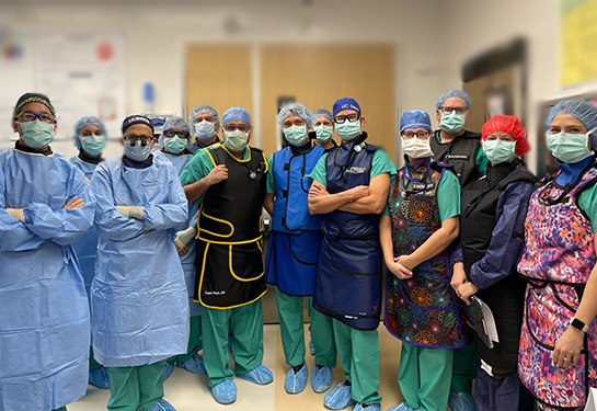 Group posing in scrubs and wearing masks