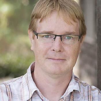 Man with glasses and plaid shirt with blond hair 