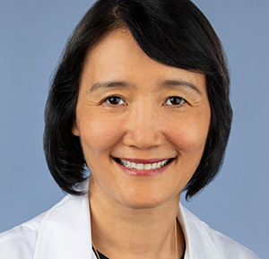 Woman smiling and wearing a white coat 