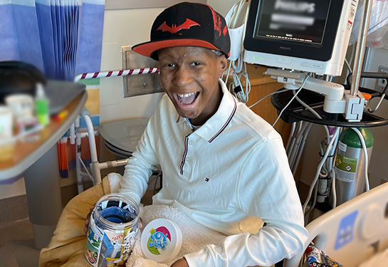 Darren Colbert smiling in a wheelchair in his hospital room