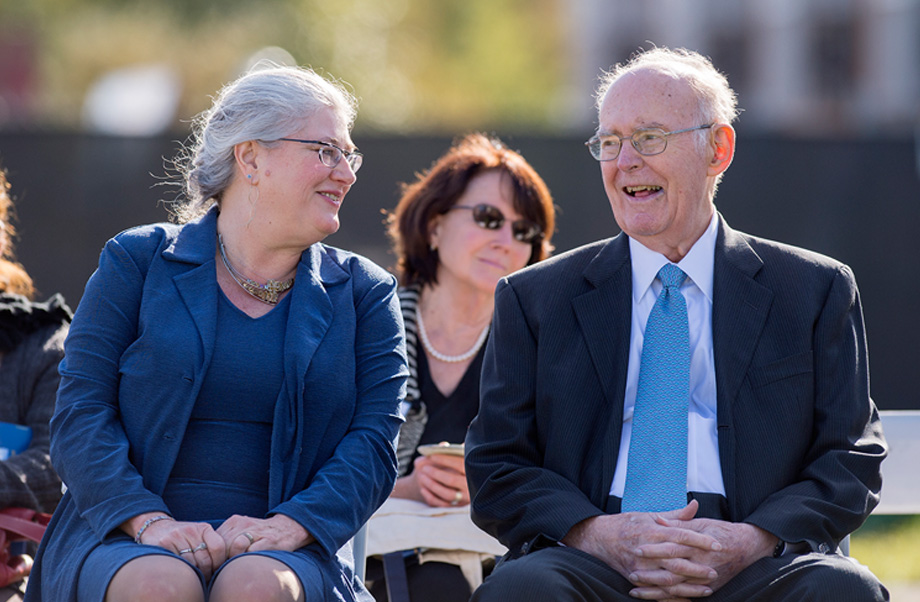 Heather Young, seated to the left, looks and smiles at Gordon Moore, who is laughing.
