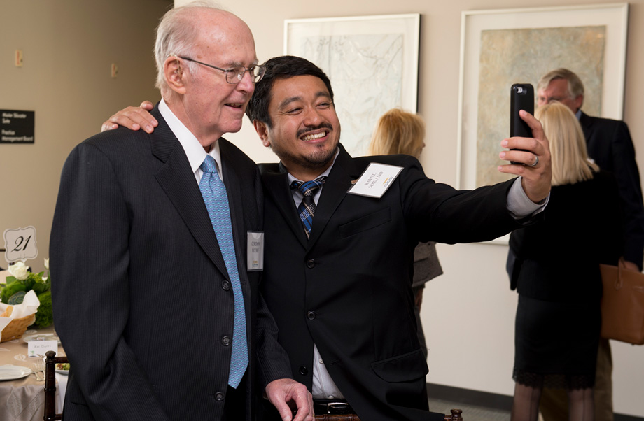 Rayne Soriano, right, has his arm around Gordon Moore while holding his mobile phone in front of the pair to take a selfie