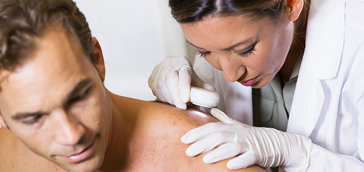 Dermatologist examing patient's skin