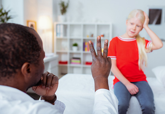 Doctor raising three fingers to diagnose girl with concussion 