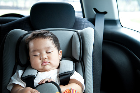 Baby boy asleep in car seat