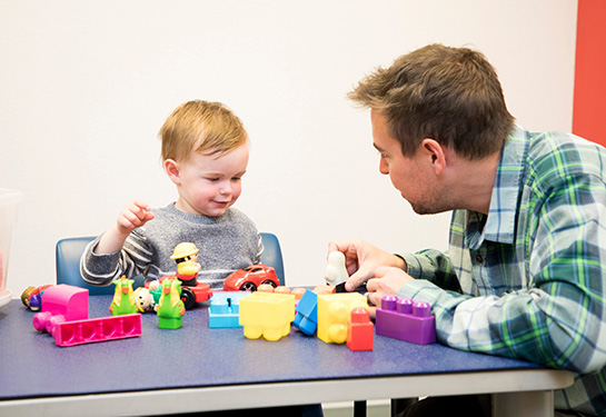 Father with son playing with blocks and Playskool figures