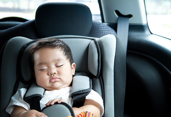 Baby boy asleep in car seat
