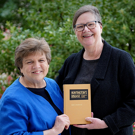 Two women holding book, showing cover of the book.