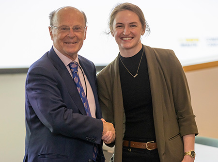 Man in suit shaking hands with young Caucasian female