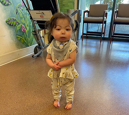 Child stands in clinic.