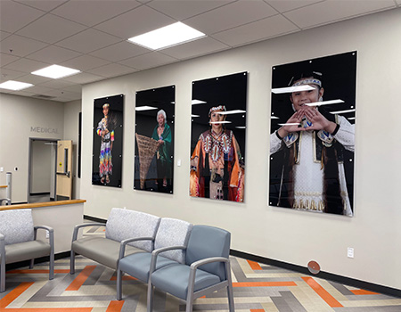 Wall of lobby displays four large photos picturing people in Native American attire. 