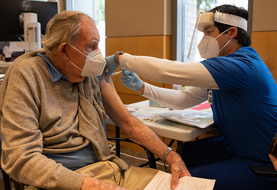 elderly man receiving vaccine in arm