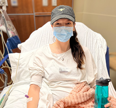 woman in a hospital bed having intravenous IVIG treatment