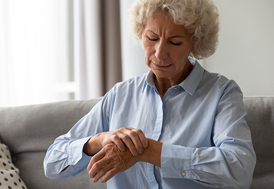 Senior woman rubbing her aching wrist 