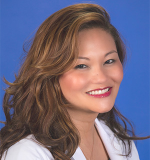 Dr. Goeanna Bautista in a white gown. She is smiling to the camera.