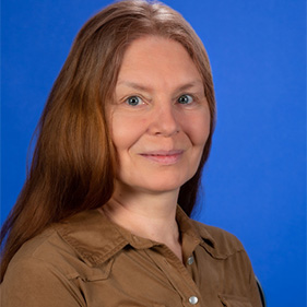 Woman with red hair wearing a brown button up shirt