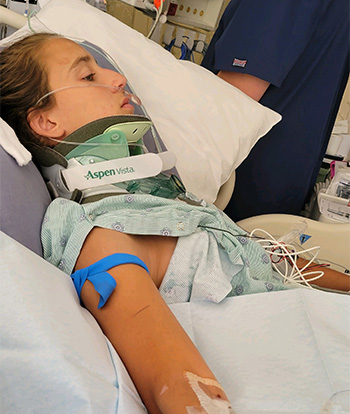 Julia in a hospital bed with a nurse beside her