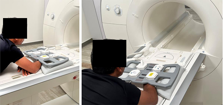 A patient is positioned on a large plastic surface in front of an MRI machine, with his arm inserted into a plastic device. 