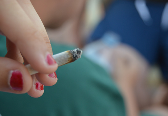 Joint in hand with young man in the background