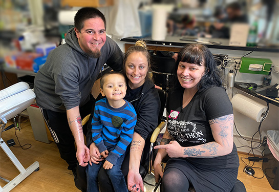 Tattoo artist with patient family 