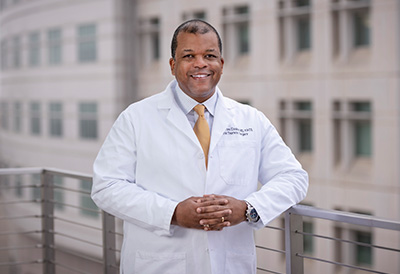Doctor in white coat smiling at camera.