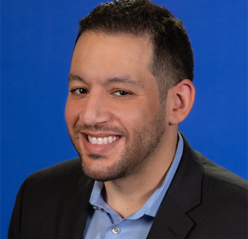 Man with beard and wearing a black suit