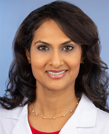 Sandhya Venugopal headshot with white lab coat and red shirt. 