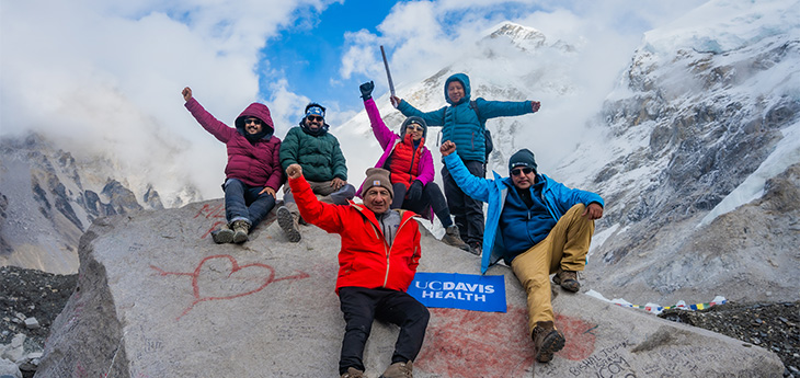 Mt. Everest hiking group with patient holding his arms in the air.