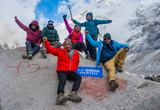 Mt. Everest hiking group with patient holding his arms in the air.