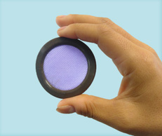 Round device that is purple in the middle and black on the outside rim held between a person's thumb and index finger