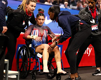 U.S. Gymnast Kayla Dicello in a wheelchair after falling on the vault. Dr. Marcy Faustin and others are caring for her.