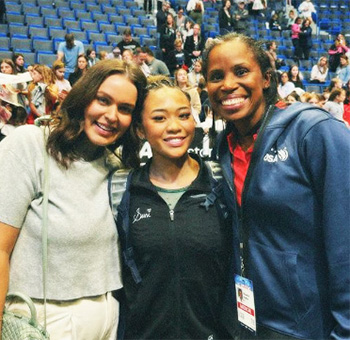 The Olympic gold medalist Sunisa Lee is standing between Dr. Marcy Faustin to her left and another person to the right.