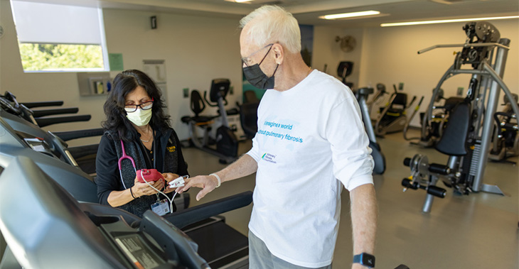 Forrest Reed standing on treadmill and getting oxygen levels tested by rehab staff