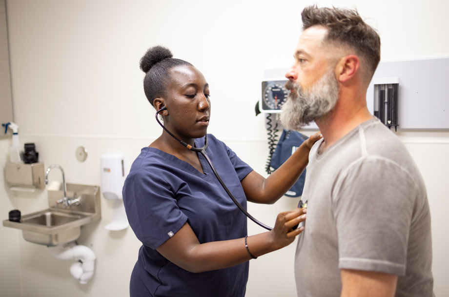 Nursing student, left, places stethoscope on patient’s chest