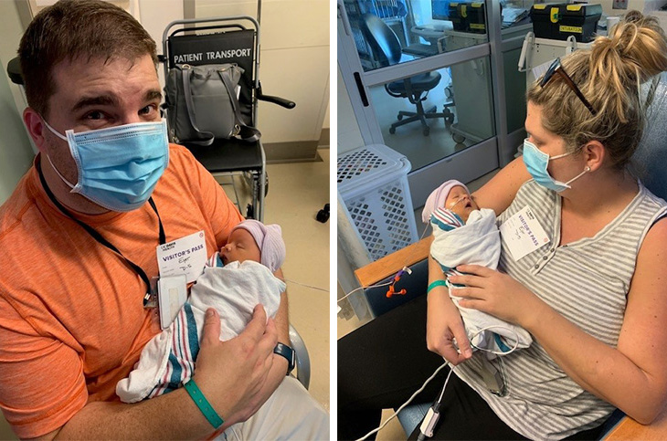 Man in orange shirt and blue mask holds a baby wrapped in a blanket. Woman in blue mask holds newborn baby in NICU.