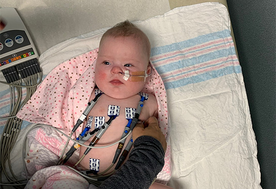 baby laying in a hospital crib