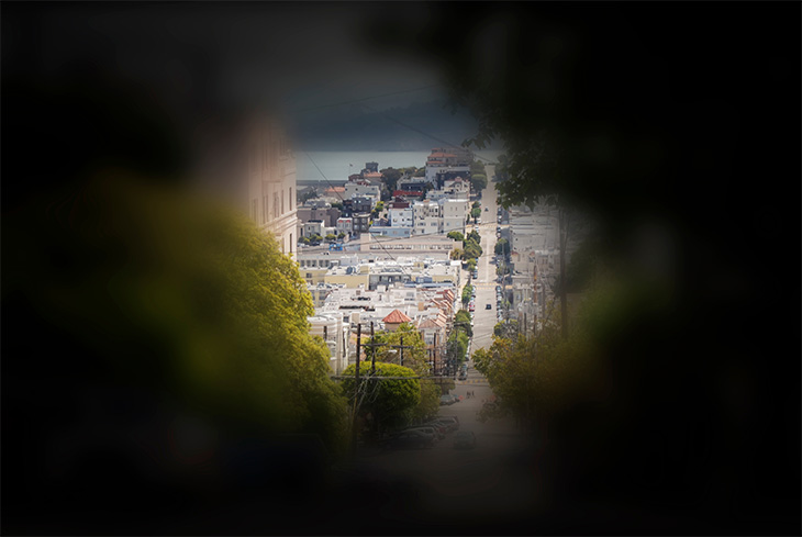 A city scene surrounded by a dark circle to show the tunnel vision that results from retinitis pigmentosa. 