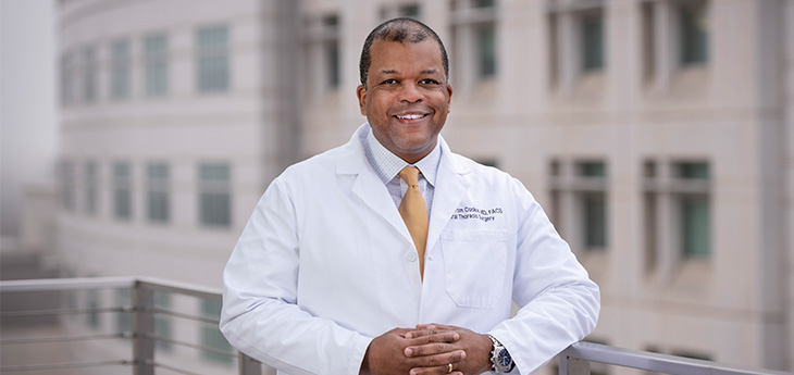 Doctor in white coat standing with hands folded