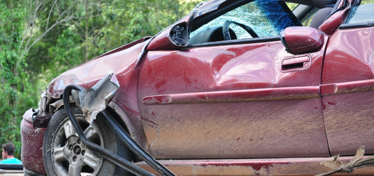 Side view of a damaged red car after a car accident