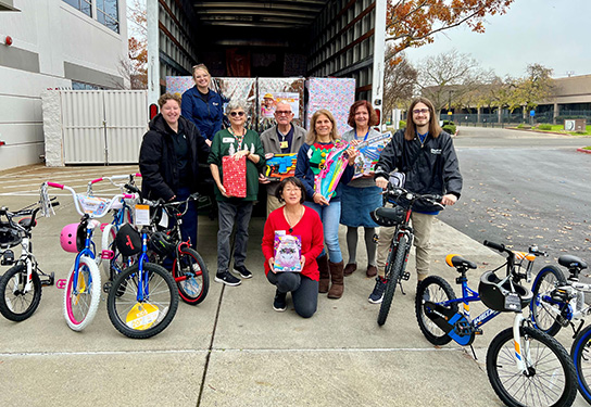 Contractors Caring for Kids participants pose with bicycles gathered for the holidays.